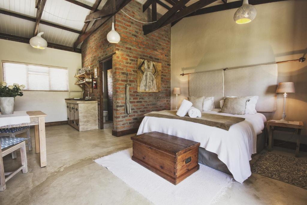 a bedroom with two beds and a brick wall at A Hilltop Country Retreat in Swellendam