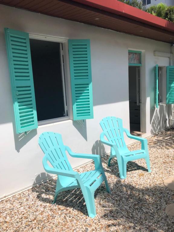two blue chairs sitting in front of a house at The Hideway in Noumea