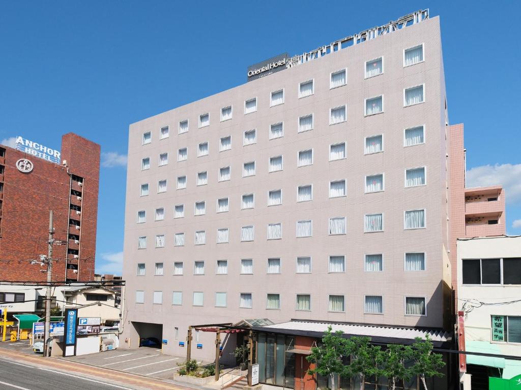 a large white building on a city street at Fukuyama Oriental Hotel in Fukuyama