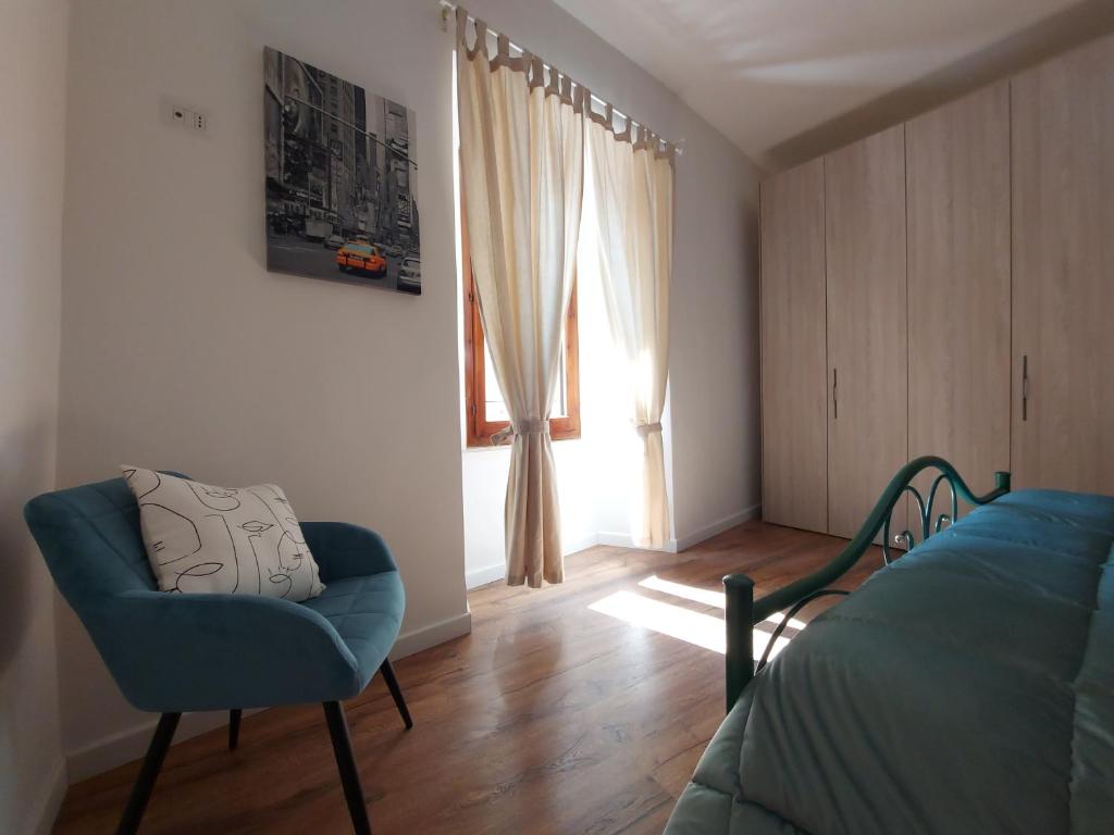 een slaapkamer met een bed, een stoel en een raam bij Da Tattallo in Assisi