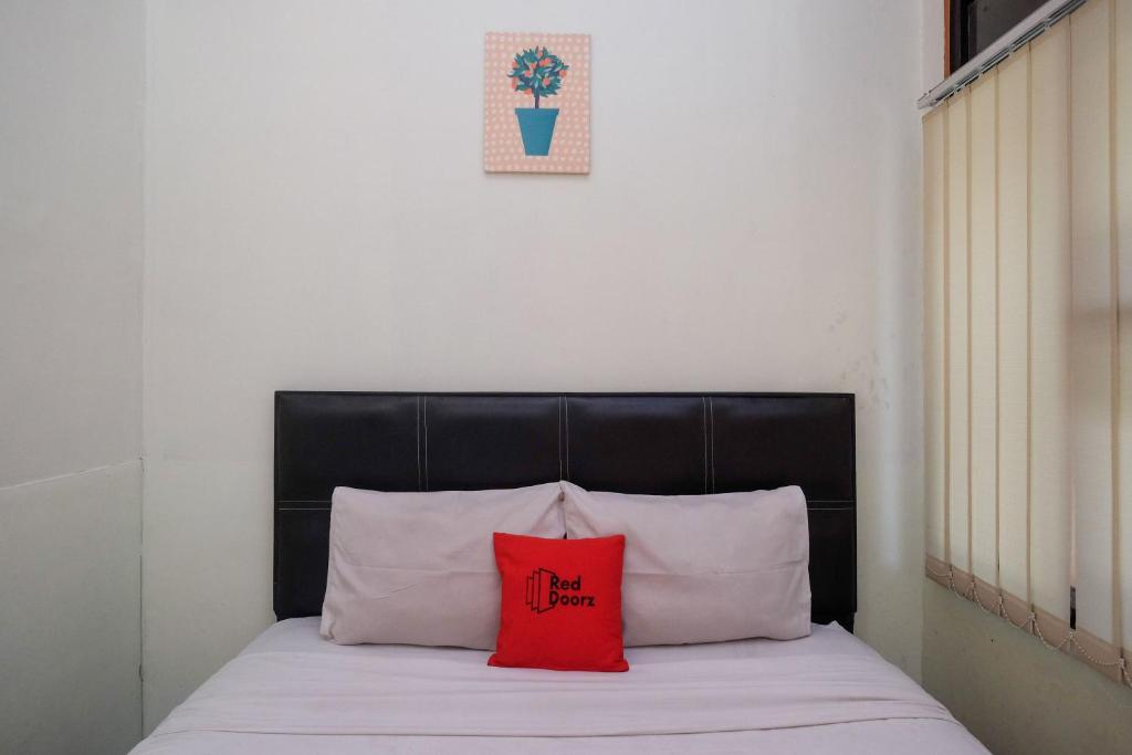 Postel nebo postele na pokoji v ubytování RedDoorz near Lotte Mart Maguwoharjo Yogyakarta