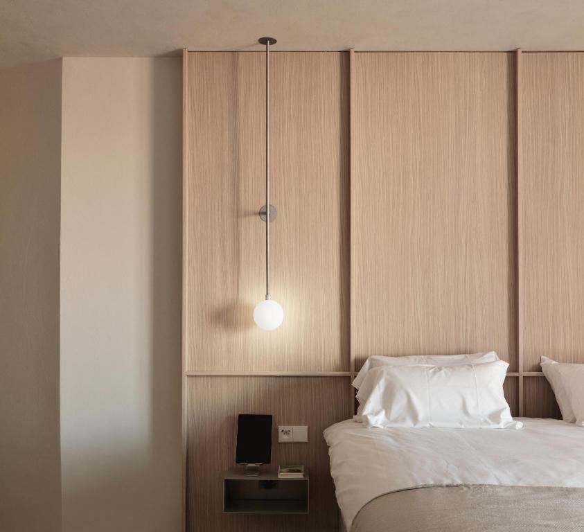 a bedroom with a bed and a night stand with a tv at Enso District Hotel in Knokke-Heist