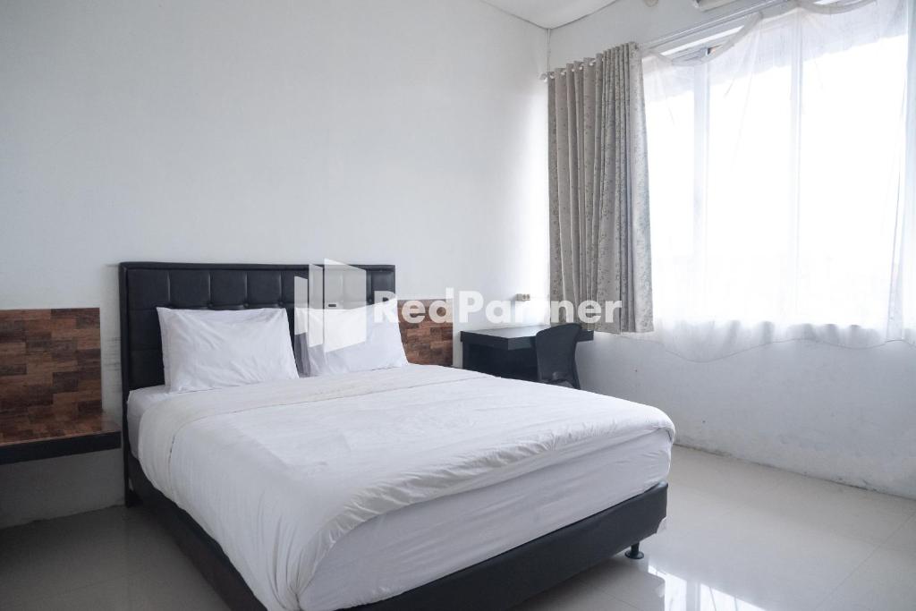 Homestay C9 Exclusive Kaliurang Yogyakarta Mitra RedDoorz tesisinde bir odada yatak veya yataklar