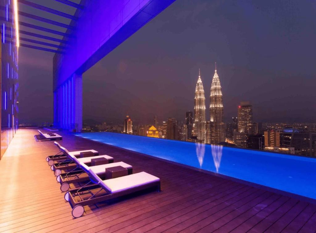 a rooftop pool with lounge chairs and a city skyline at The Platinum KLCC in Kuala Lumpur
