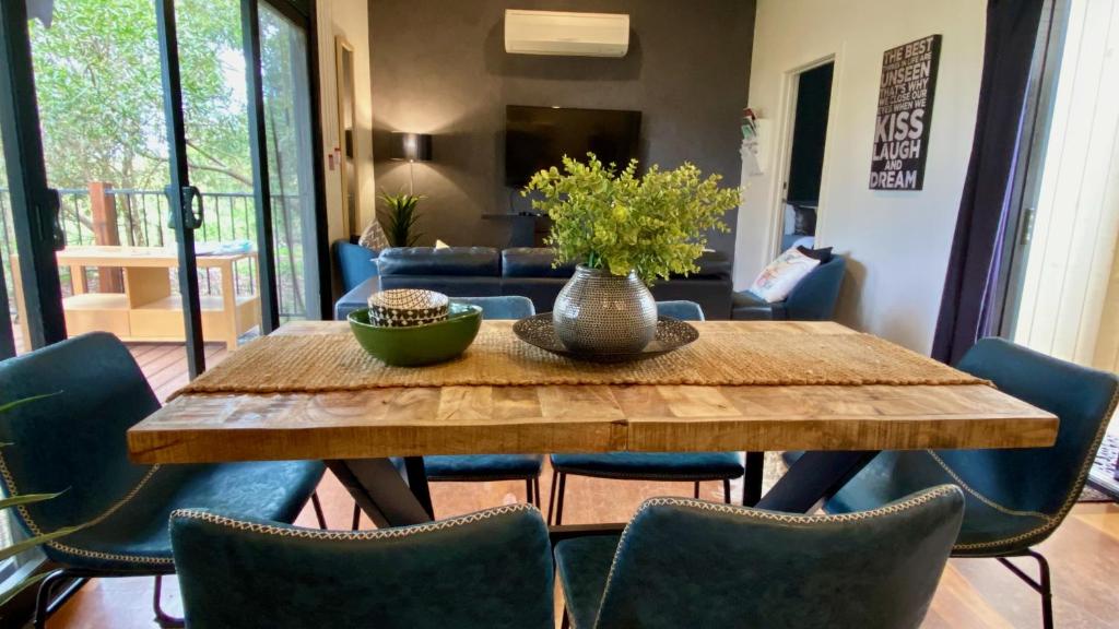 einem Esstisch mit Stühlen und einer Vase darauf in der Unterkunft Phillip Island Nature Resort Villas in Cowes