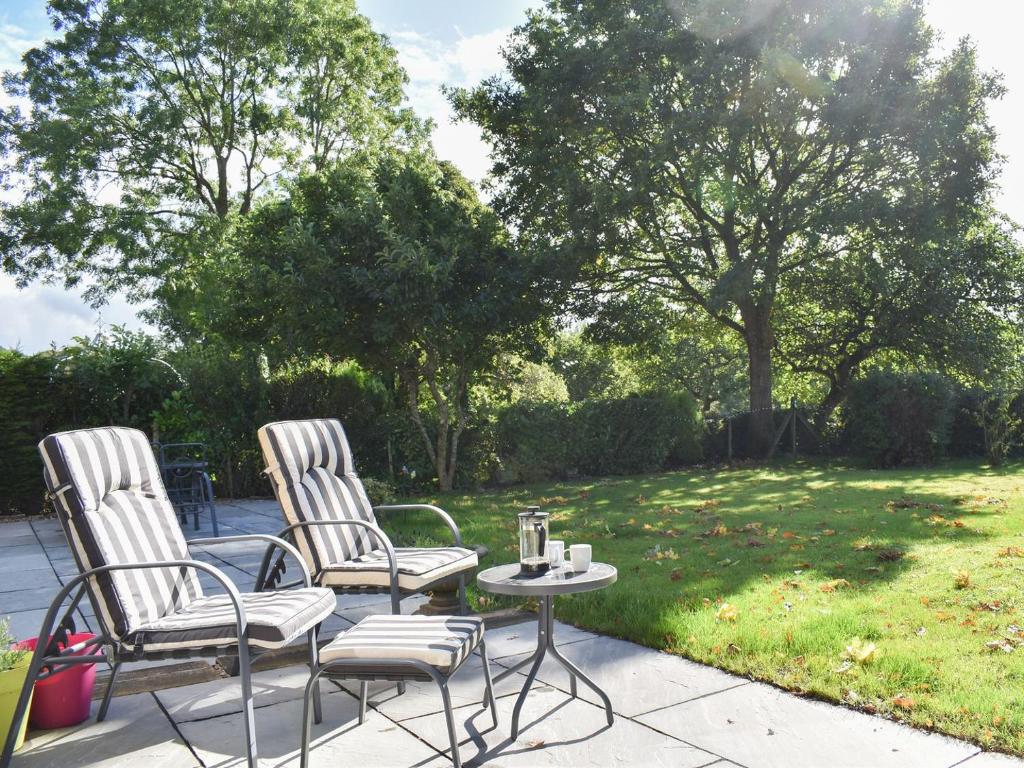 2 sillas y una mesa en el patio en Stone Cottage, en Wingerworth