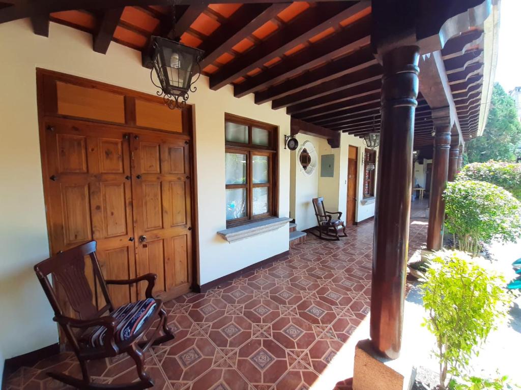 Hotel Posada San Felipe في أنتيغوا غواتيمالا: شرفة منزل مع كرسي ونافذة
