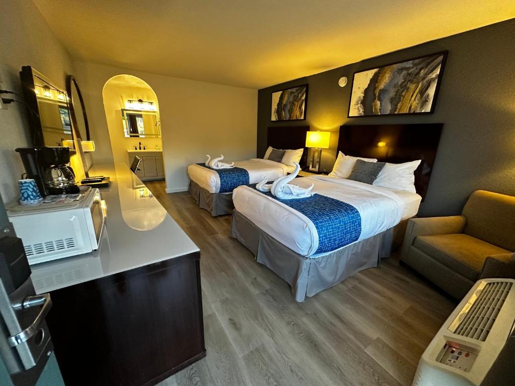 Habitación de hotel con 2 camas y sofá en Sierra Inn, en San Andreas