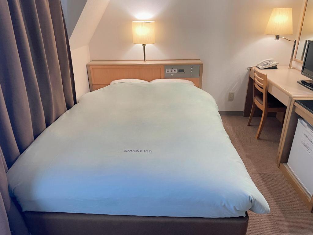Un pat sau paturi într-o cameră la Olympic Inn Kanda