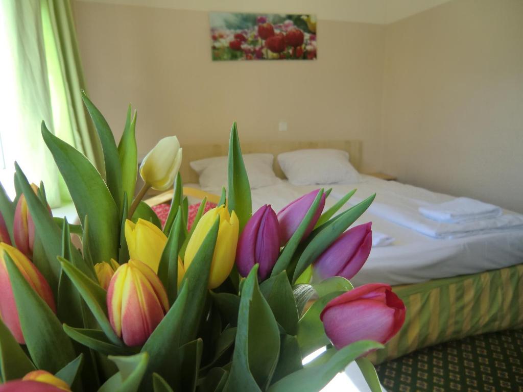 a room with a bed with a bunch of flowers at Panorama Hotel Frankfurt Offenbach Süd in Offenbach