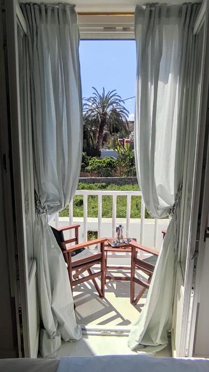 a door open to a porch with a bench and a table at Marietta's House in Rhodes Town