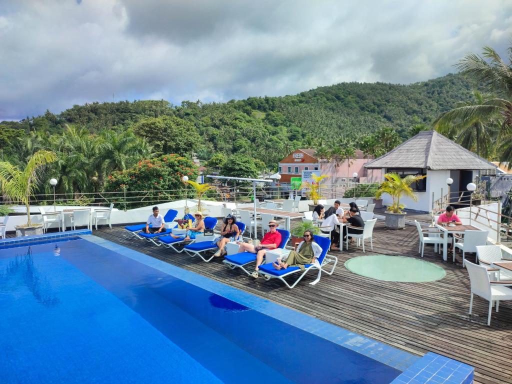 un gruppo di persone seduti su sedie a bordo piscina di Taman Unique Hotel a Senggigi