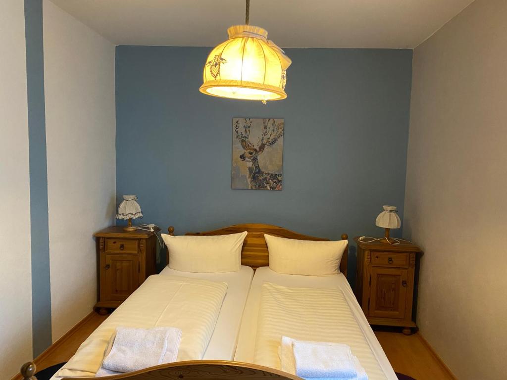 1 dormitorio con cama y lámpara de araña en Gasthaus Goa, en Ernsthausen