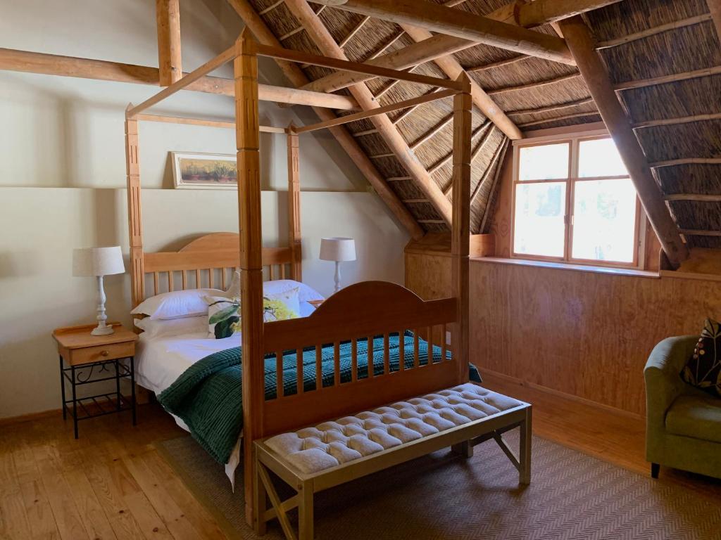 a bedroom with a canopy bed in a room at Port Wine Guesthouse in Calitzdorp