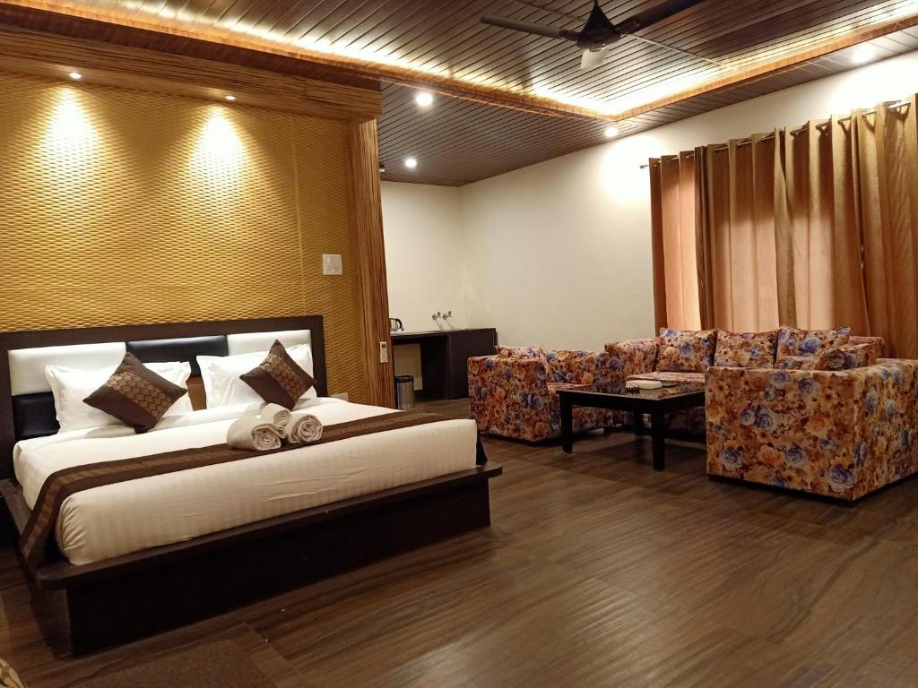 a bedroom with a bed and two chairs and a couch at Skywood Resort Shoghi in Shogi