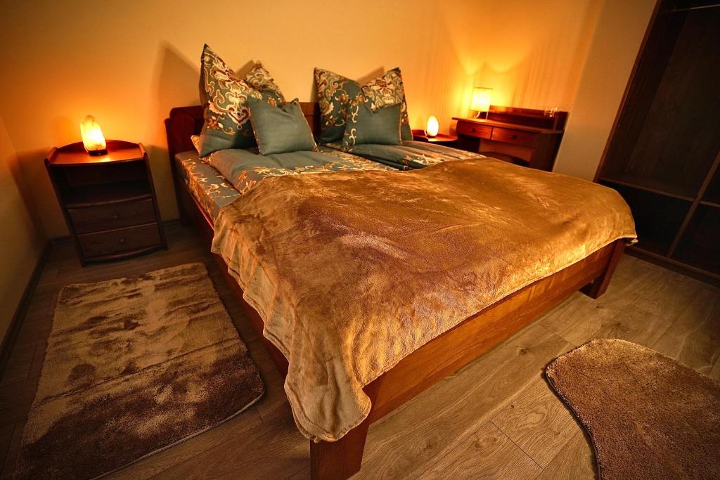 una camera da letto con un grande letto con due comodini di Bacchus Pub és Panzió a Dunaharaszti