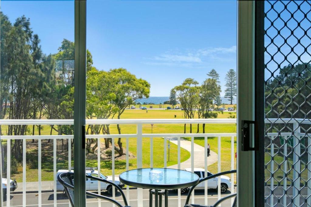 a view from a balcony with a table and chairs at Beach Park Motel in North Wollongong