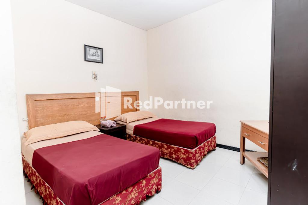 Postel nebo postele na pokoji v ubytování Cherry Pink Hotel Medan Mitra RedDoorz