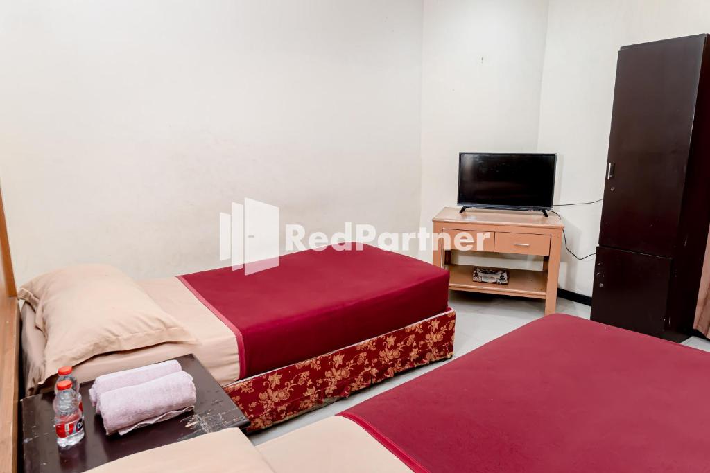 Postel nebo postele na pokoji v ubytování Cherry Pink Hotel Medan Mitra RedDoorz