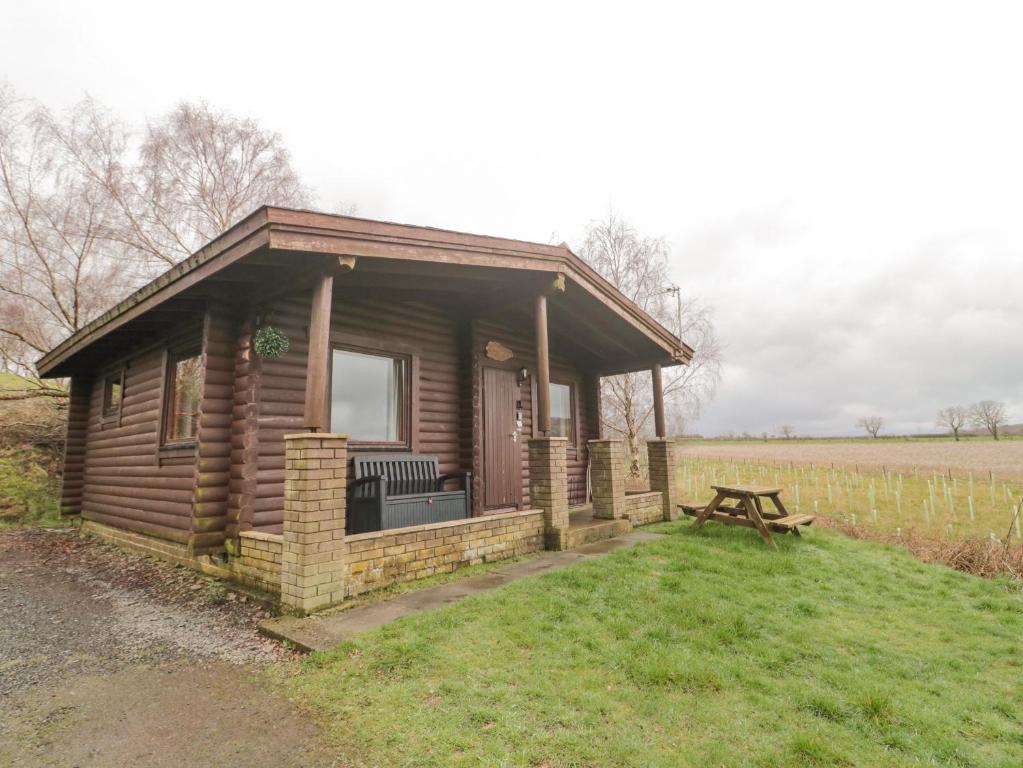 a small cabin with a picnic table in a field at Glanton in Morpeth
