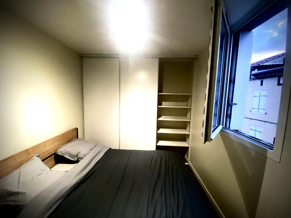 een kleine kamer met een bed en een raam bij Etoiles Résidence de l'agout in Castres