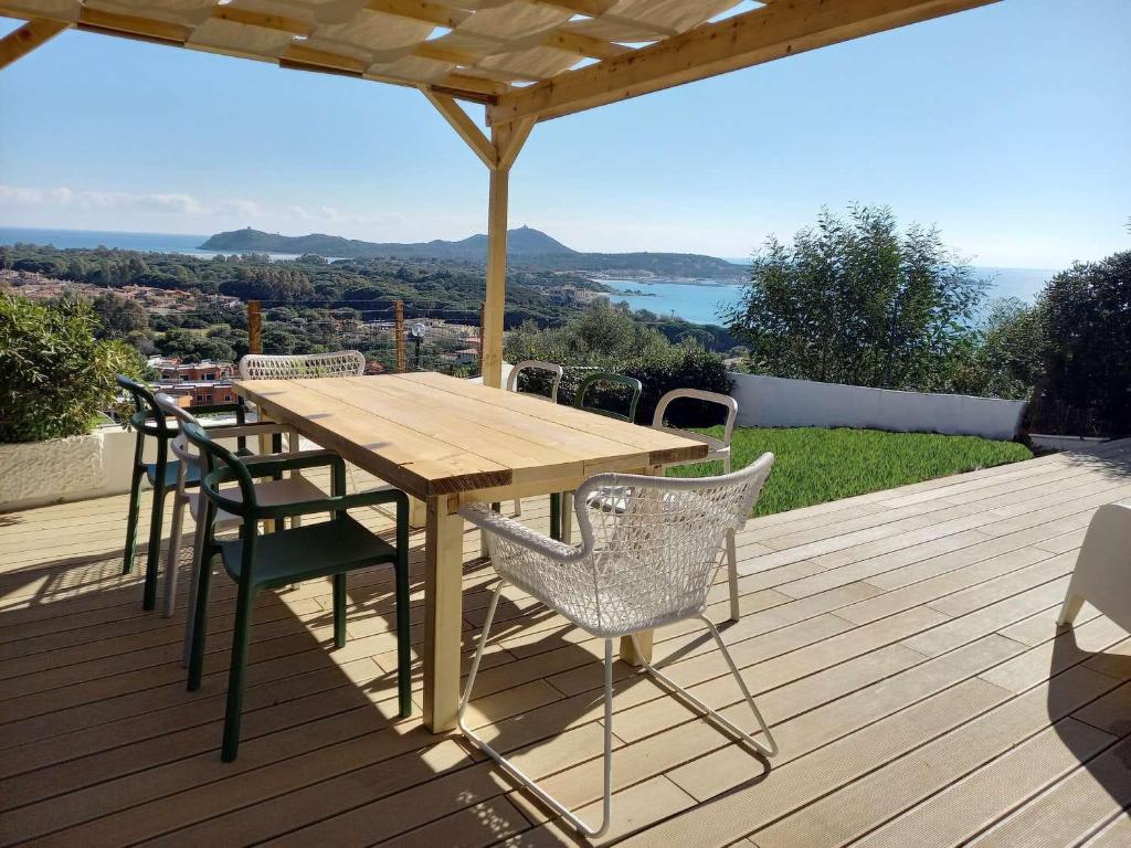 una terraza de madera con mesa y sillas de madera en Casa Buenavista Villasimius, en Villasimius