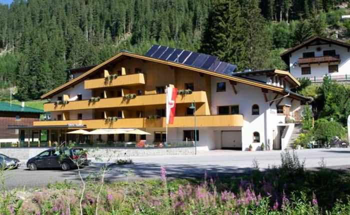 ein großes Gebäude mit einem Parkplatz davor in der Unterkunft Gasthof Waldesruh in Oetz