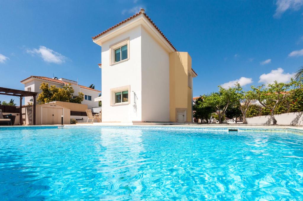 a villa with a swimming pool in front of a house at Villa Carolina in Ayia Napa
