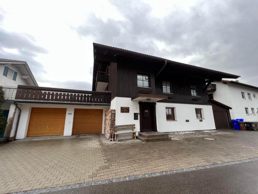 a white and black house with two garage doors at Chalet Alpenflair in Pfronten