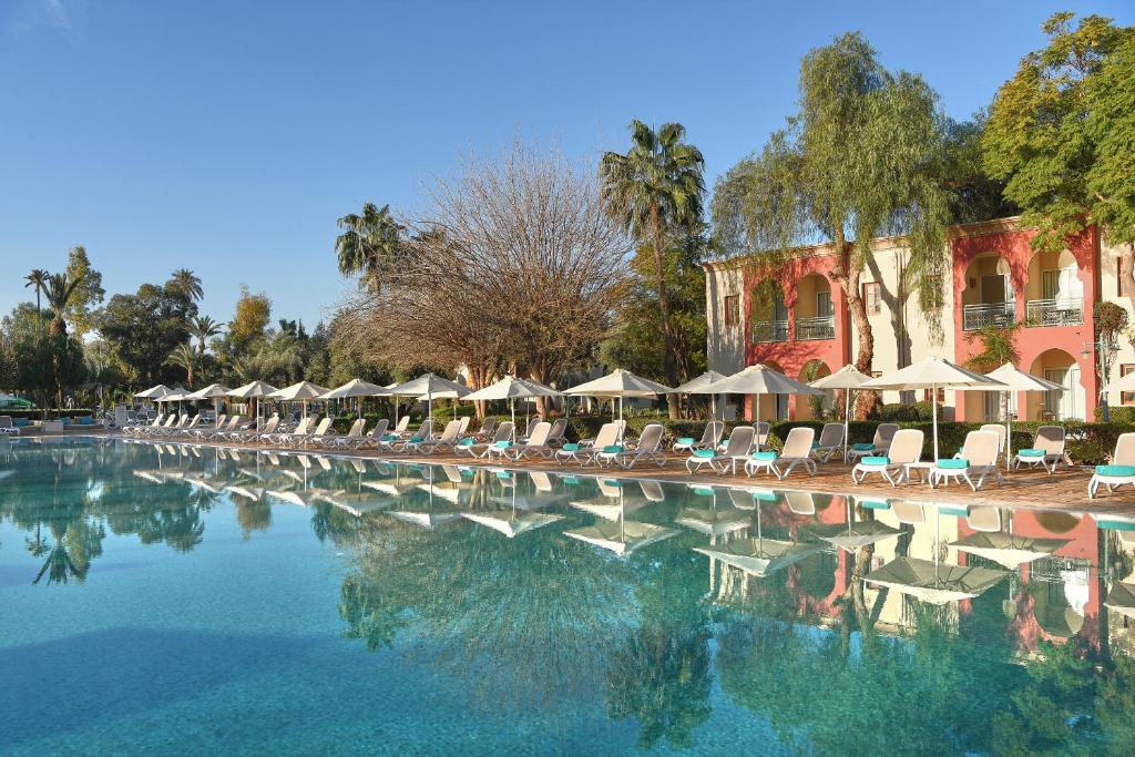 uma grande piscina com cadeiras e guarda-sóis em Iberostar Club Palmeraie Marrakech All Inclusive em Marraquexe