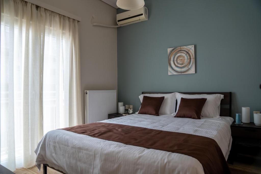 a bedroom with a large bed and a large window at Sea View Volos in Volos
