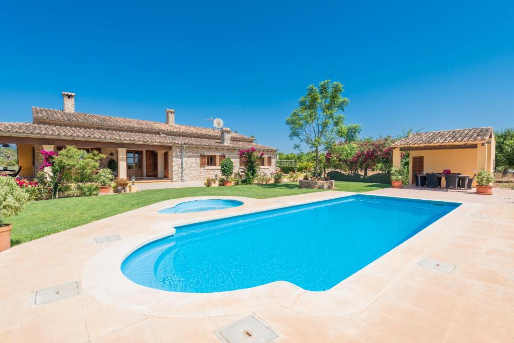 un'immagine di una piscina di fronte a una casa di Carretxet a Sa Pobla