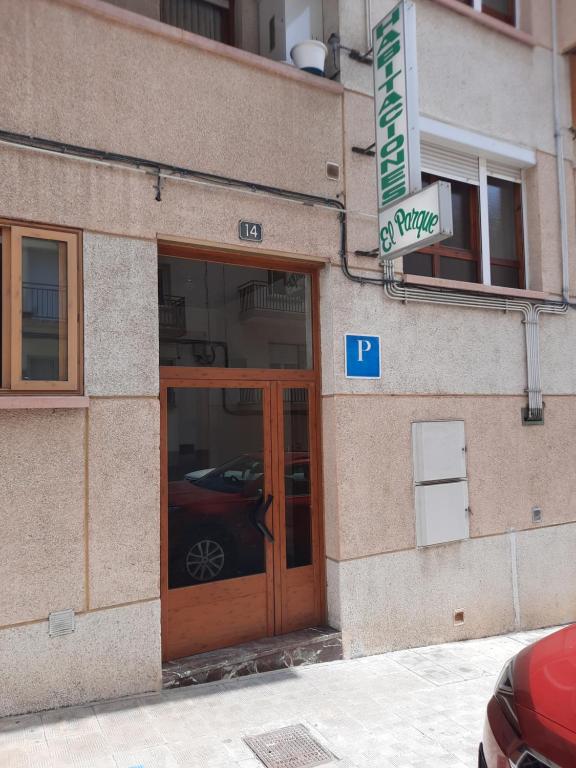 un edificio con una señal de estacionamiento frente a una puerta en HABITACIONES PENSION EL PARQUE, en Sabiñánigo