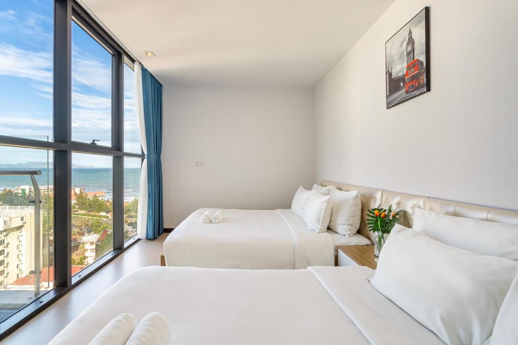 two beds in a room with a view of the ocean at CSJ Seaside - Căn Hộ Cạnh Biển in Vung Tau