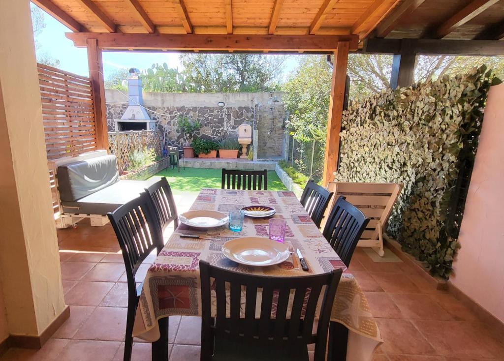 un tavolo e sedie in un patio con tavolo di Villetta Eliselena Best Vacation Ever a Villasimius