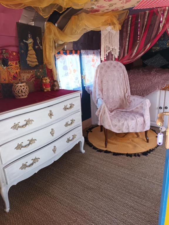 sypialnia z komodą, krzesłem i łóżkiem w obiekcie Git'an Périgord la Bonne aventure w mieście Groléjac
