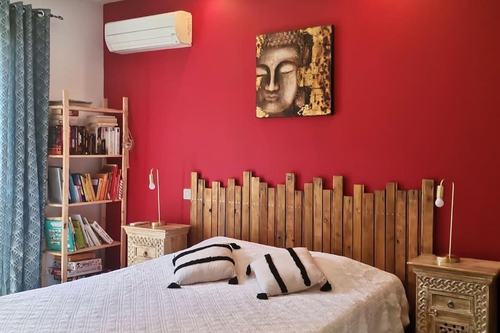 a bedroom with red walls and a bed with two pillows at Maison avec jacuzzi au cœur des montagnes in Feliceto