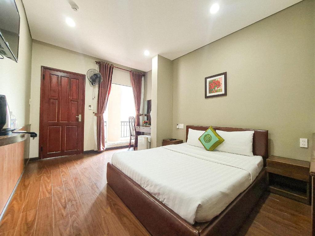 a bedroom with a large bed and a large window at Quan Quan Hotel in Danang