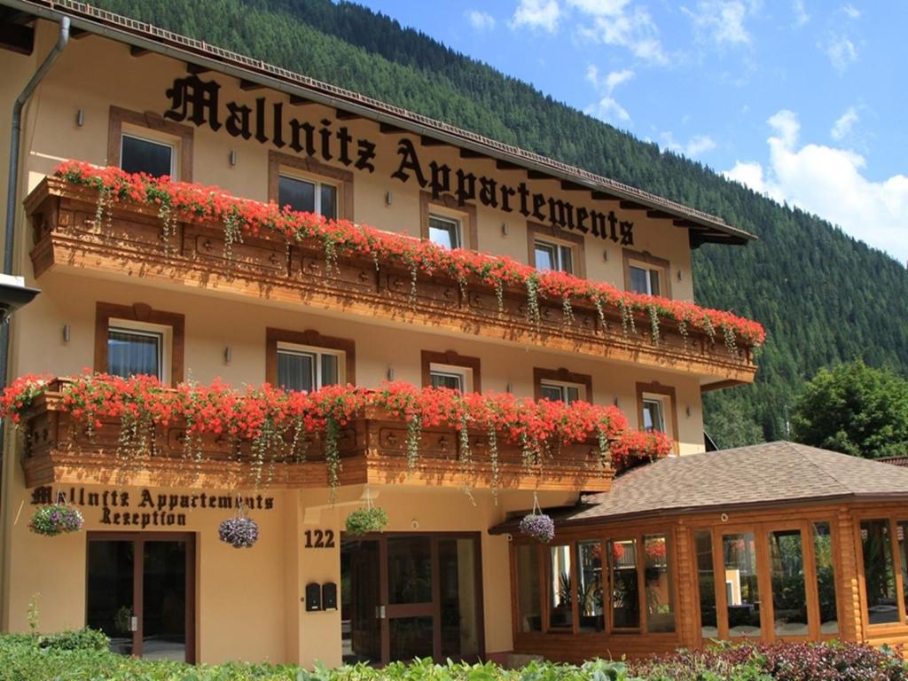 un hotel con flores rojas al costado. en Hotel Mallnitz, en Mallnitz