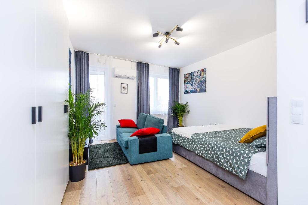 een slaapkamer met een bed en een blauwe stoel bij Cloud9 - Barska 69 in Krakau
