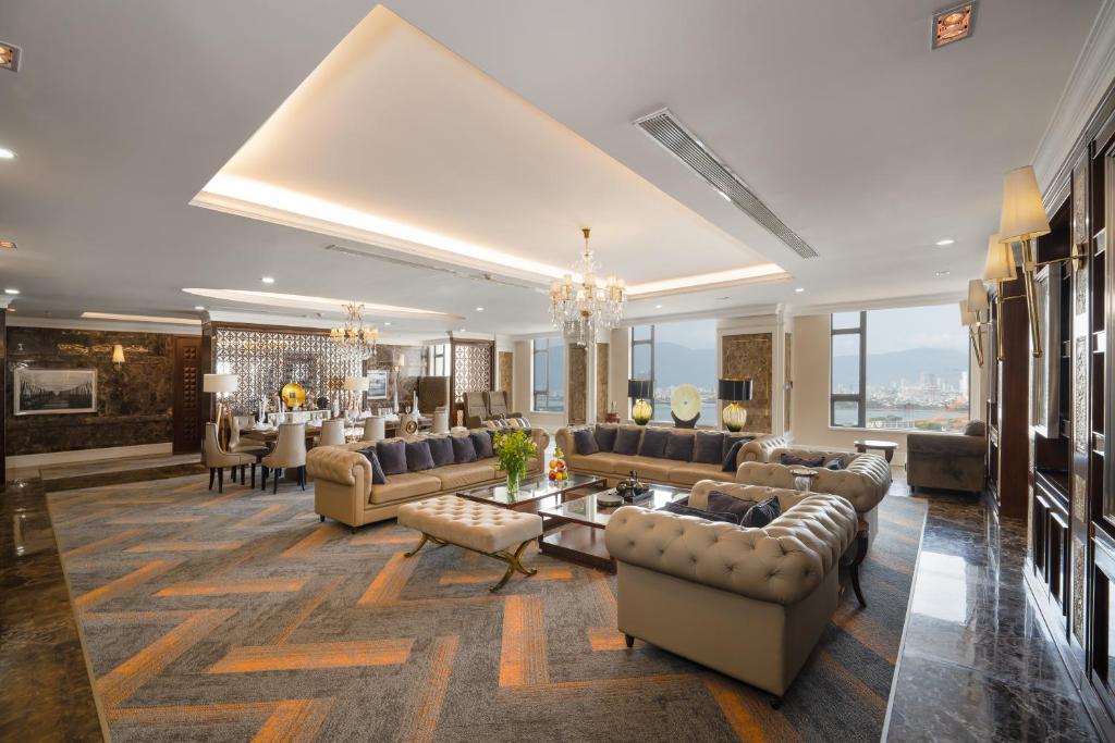 Minh Toan Galaxy Hotel في دا نانغ: غرفة معيشة كبيرة مع كنب وثريا