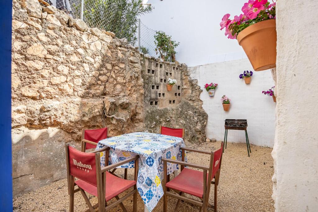 una mesa y sillas con una mesa y una pared en Casa Rural La Clau, en Polop