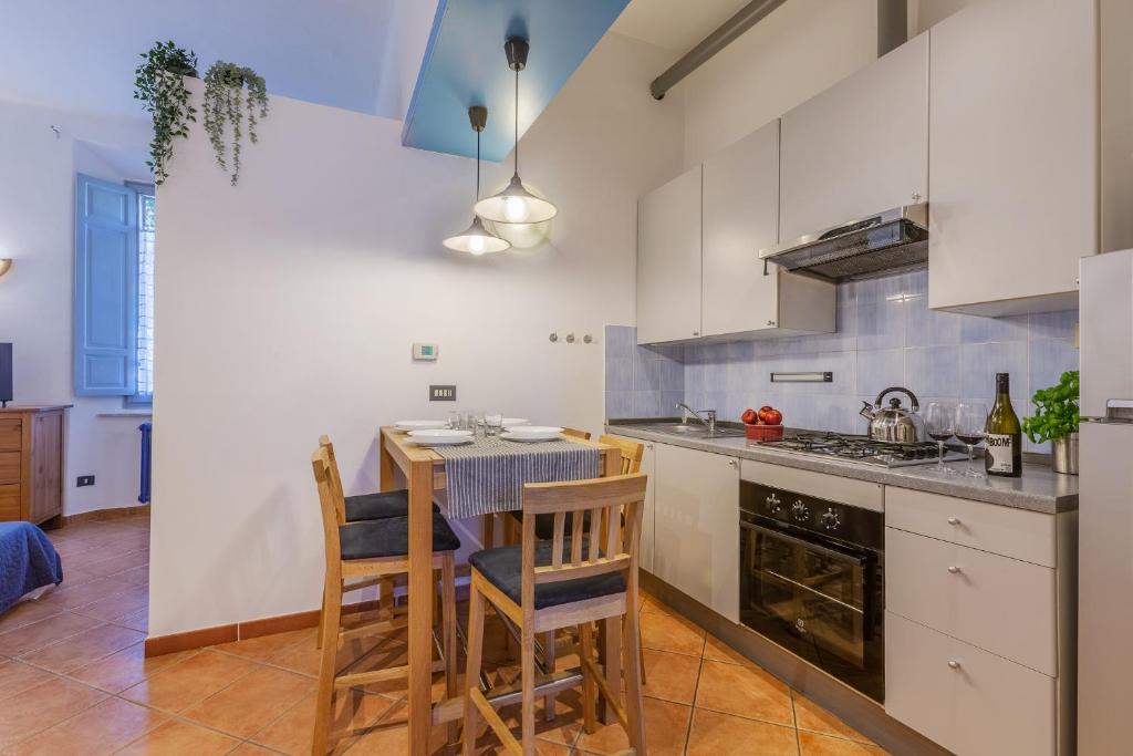 cocina con mesa y sillas en una habitación en Ferrara Station Essential Apartment with parking, en Ferrara