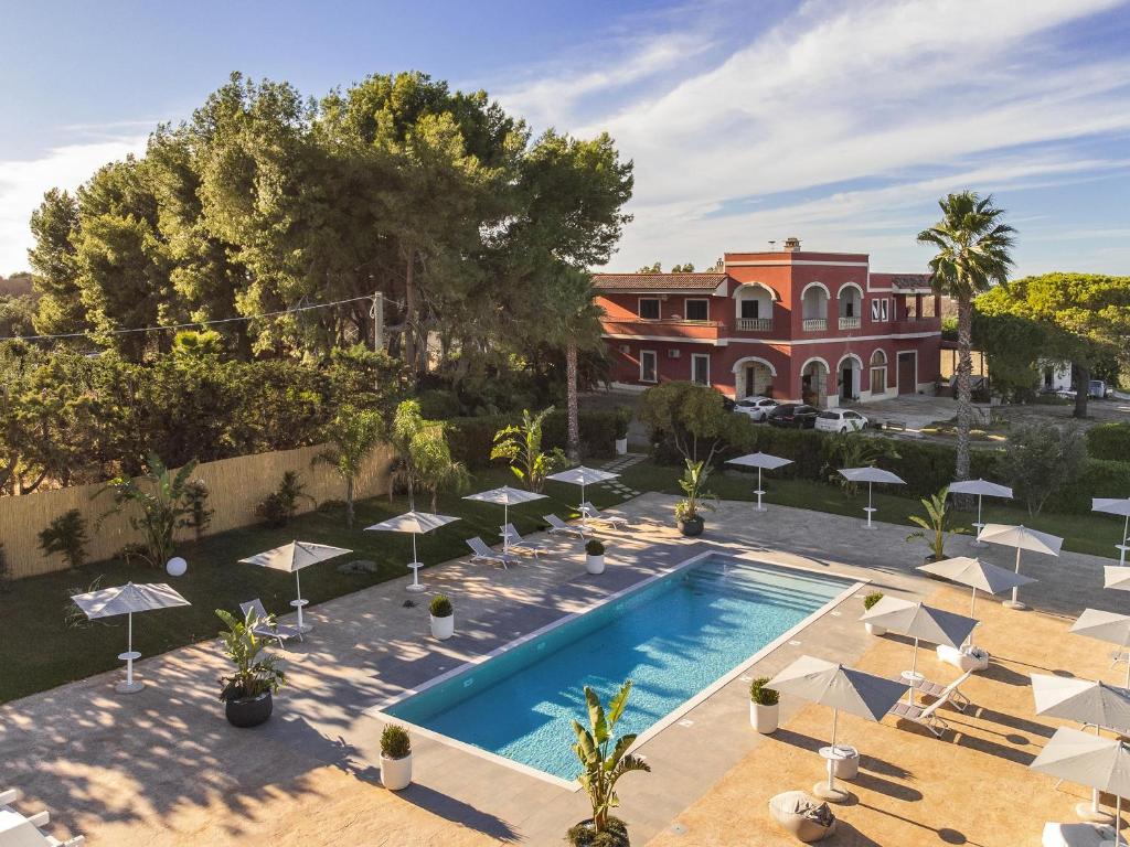 an overhead view of a swimming pool with umbrellas and a house at Tenuta Cavalieri in Leverano