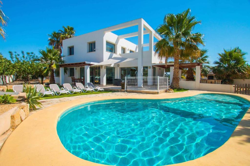 a villa with a swimming pool in front of a house at Villa Athos - PlusHolidays in Calpe