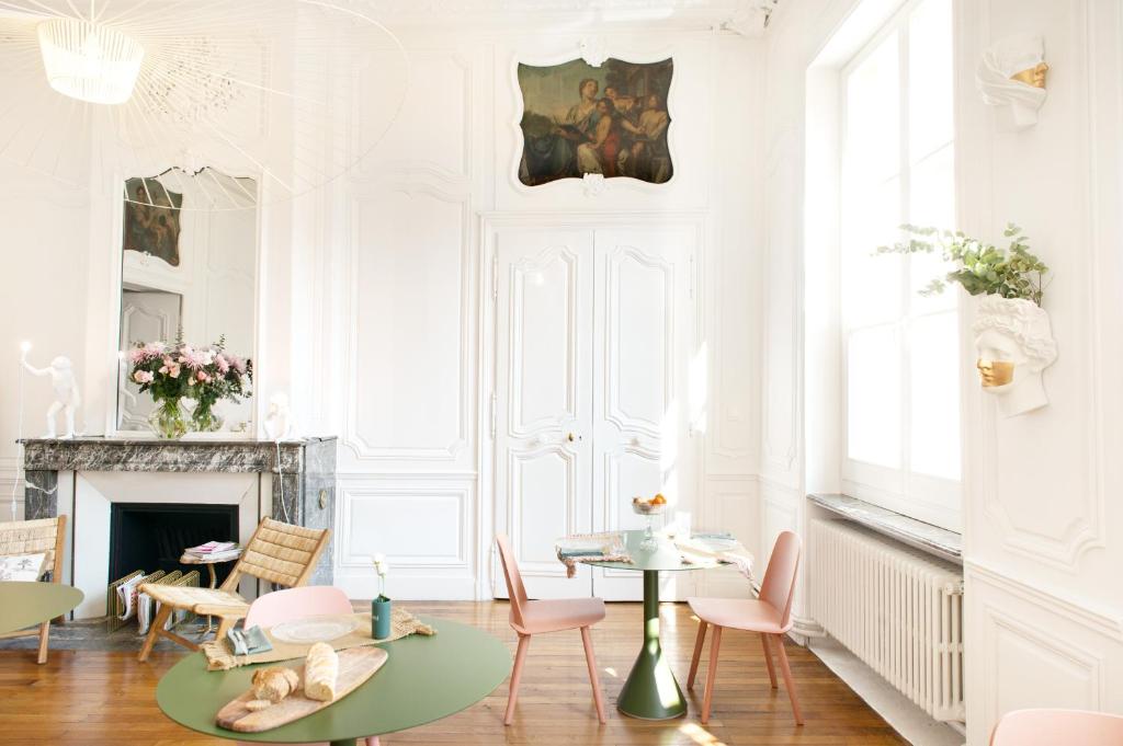 uma sala de estar com uma mesa e cadeiras e uma lareira em Hotel de Fouquet - Chambres d'hôtes em Metz