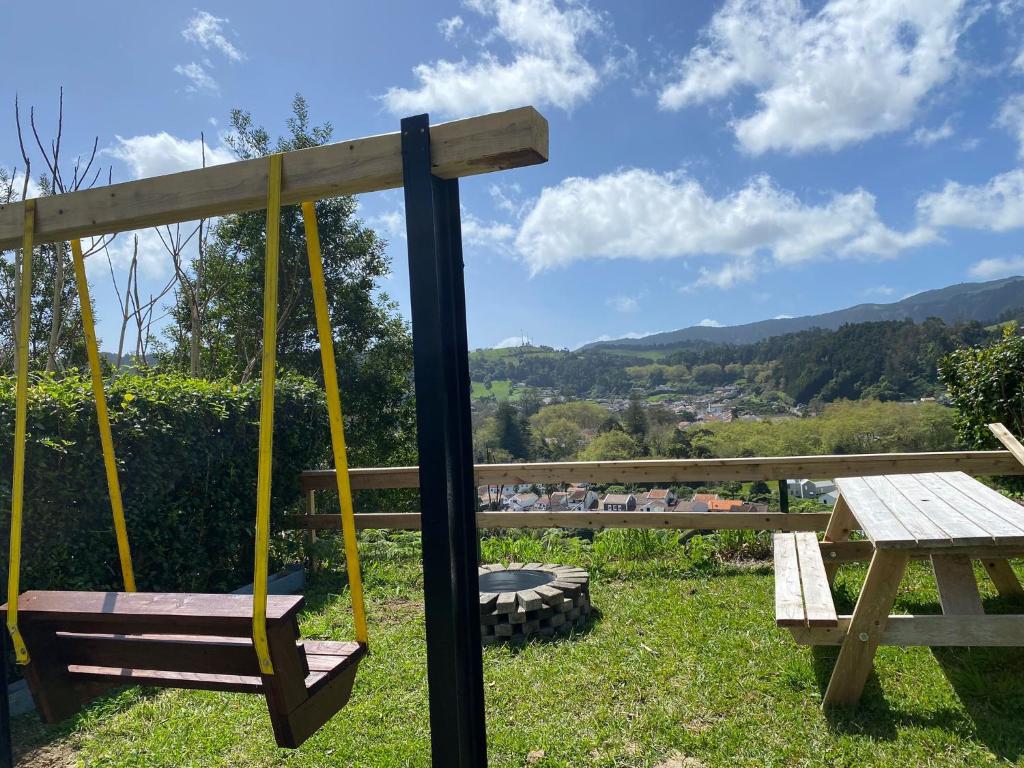 a swing and a picnic table with a view at Casa da Vista- Eirinha in Furnas