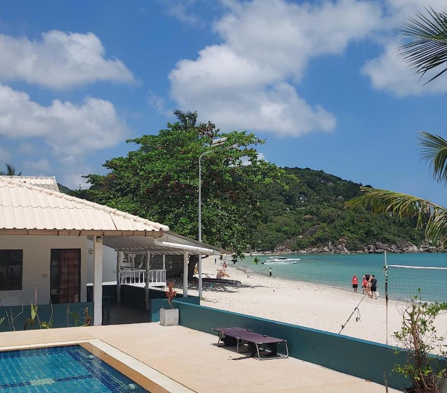 een huis met een zwembad naast een strand bij Thong Nai Pan Beach Resort in Thong Nai Pan Yai