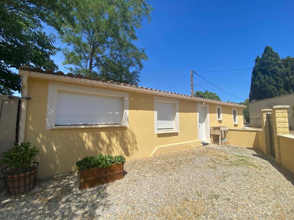 uma casa amarela com duas janelas numa entrada em Villa Premium 3 étoiles sur Terrain clos de 300 M2 em Bagnols-sur-Cèze
