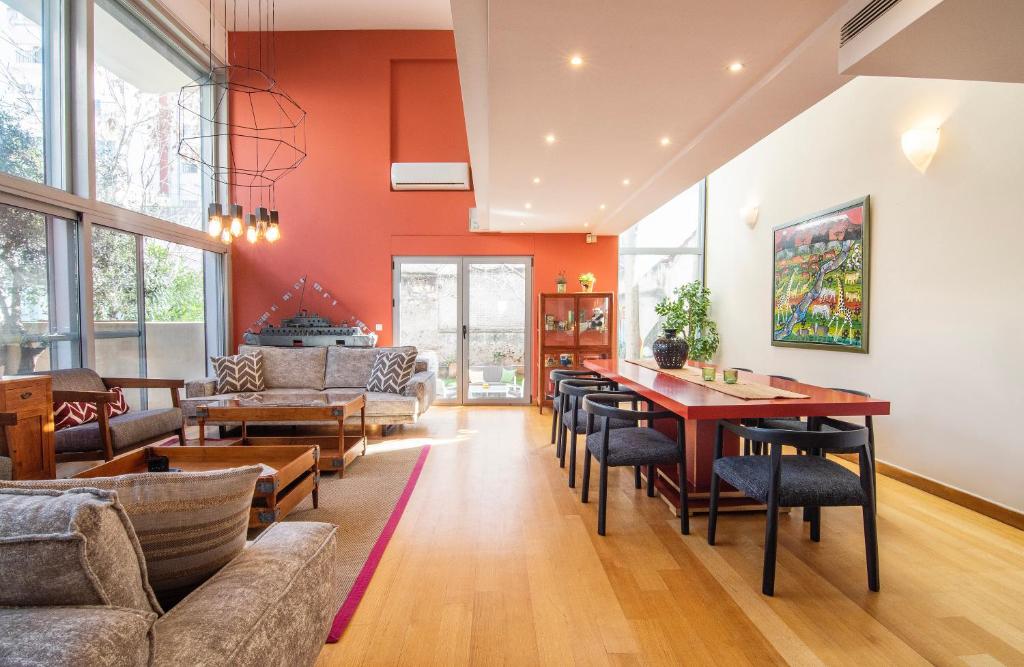 a living room with orange walls and a table and chairs at Villa Amaryllis in Athens